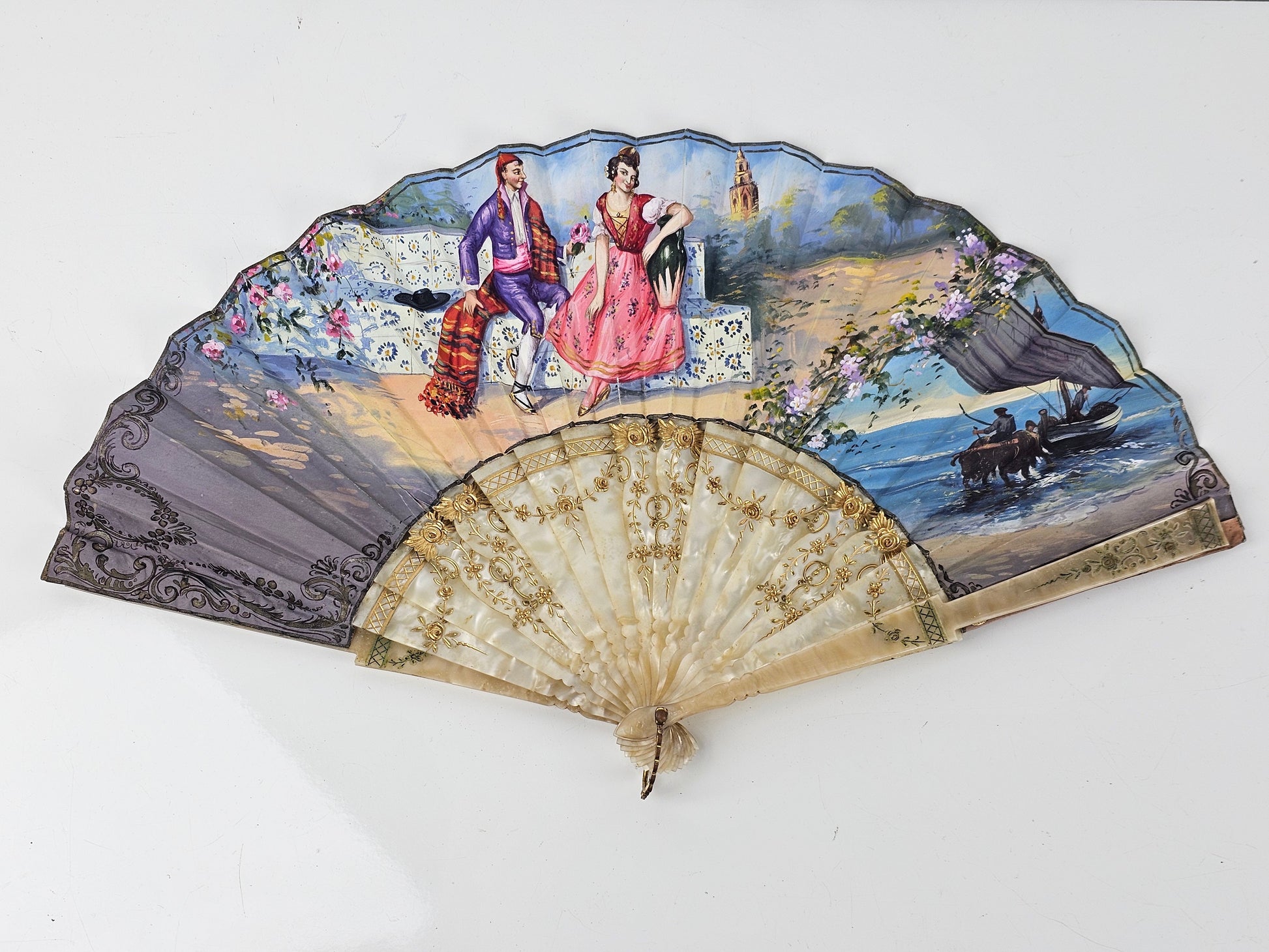 Decorative fan with painted scene on a white background