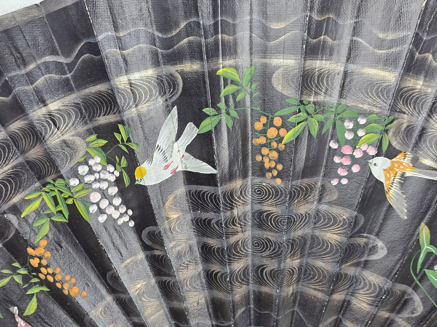 Decorative fabric with birds, flowers, and abstract patterns on a black background