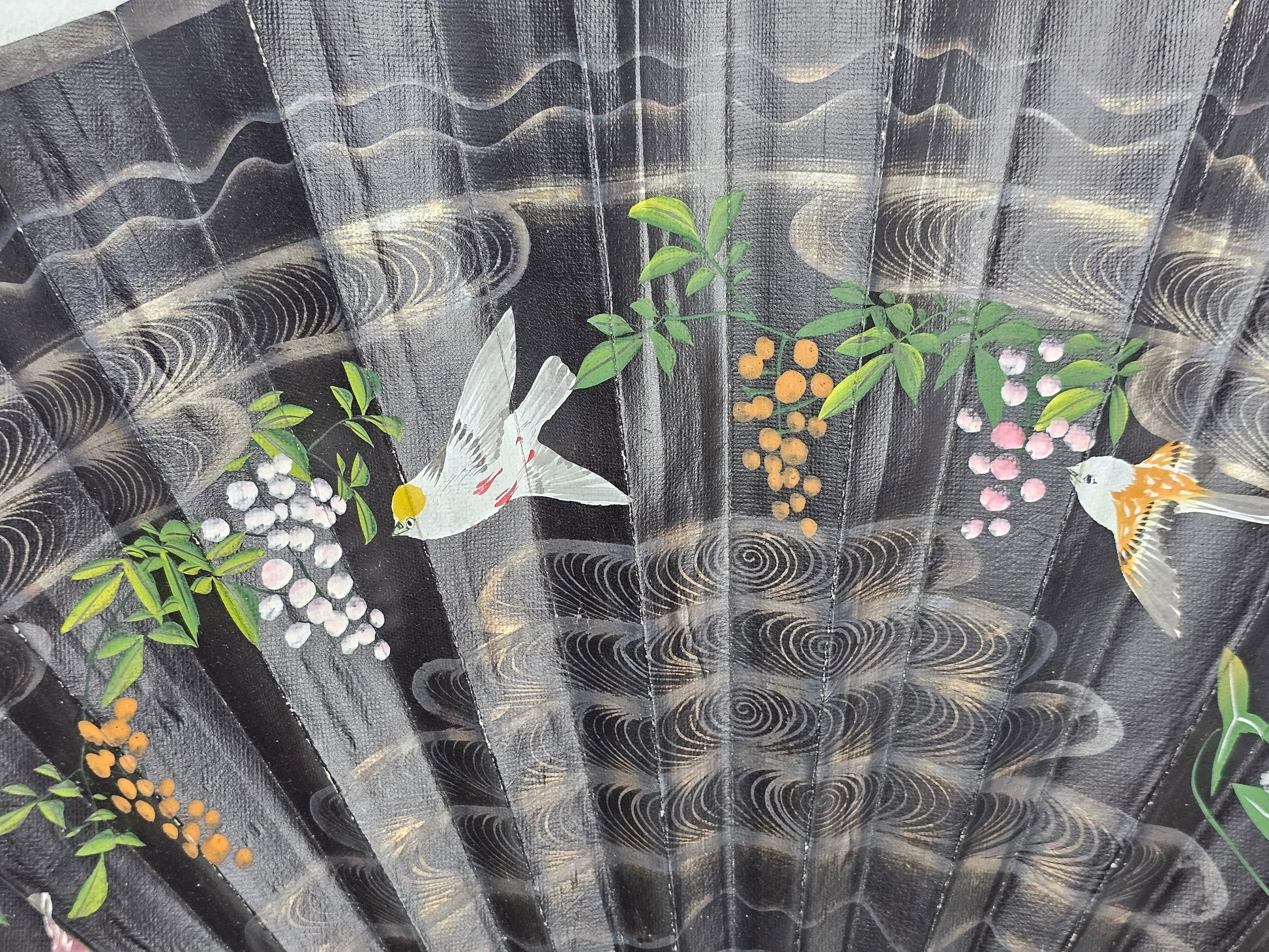 Decorative fabric with birds, flowers, and abstract patterns on a black background