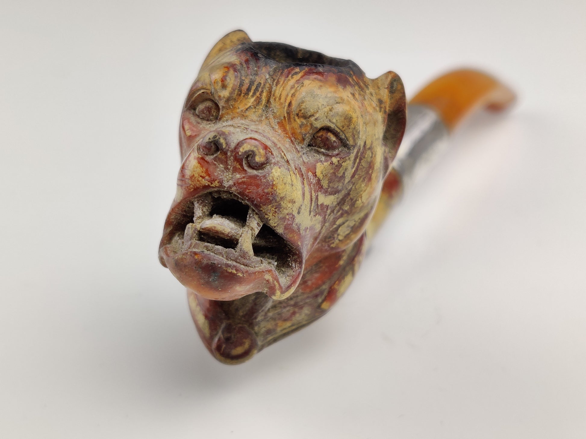 Decorative smoking pipe with a detailed animal head design on a white background